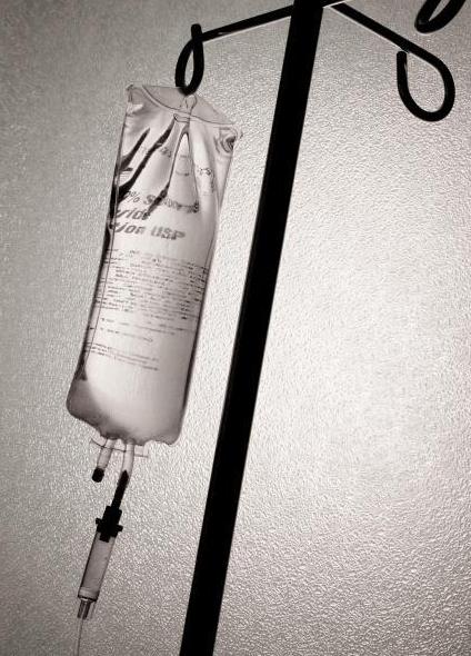 Saline drip elevated above the patient